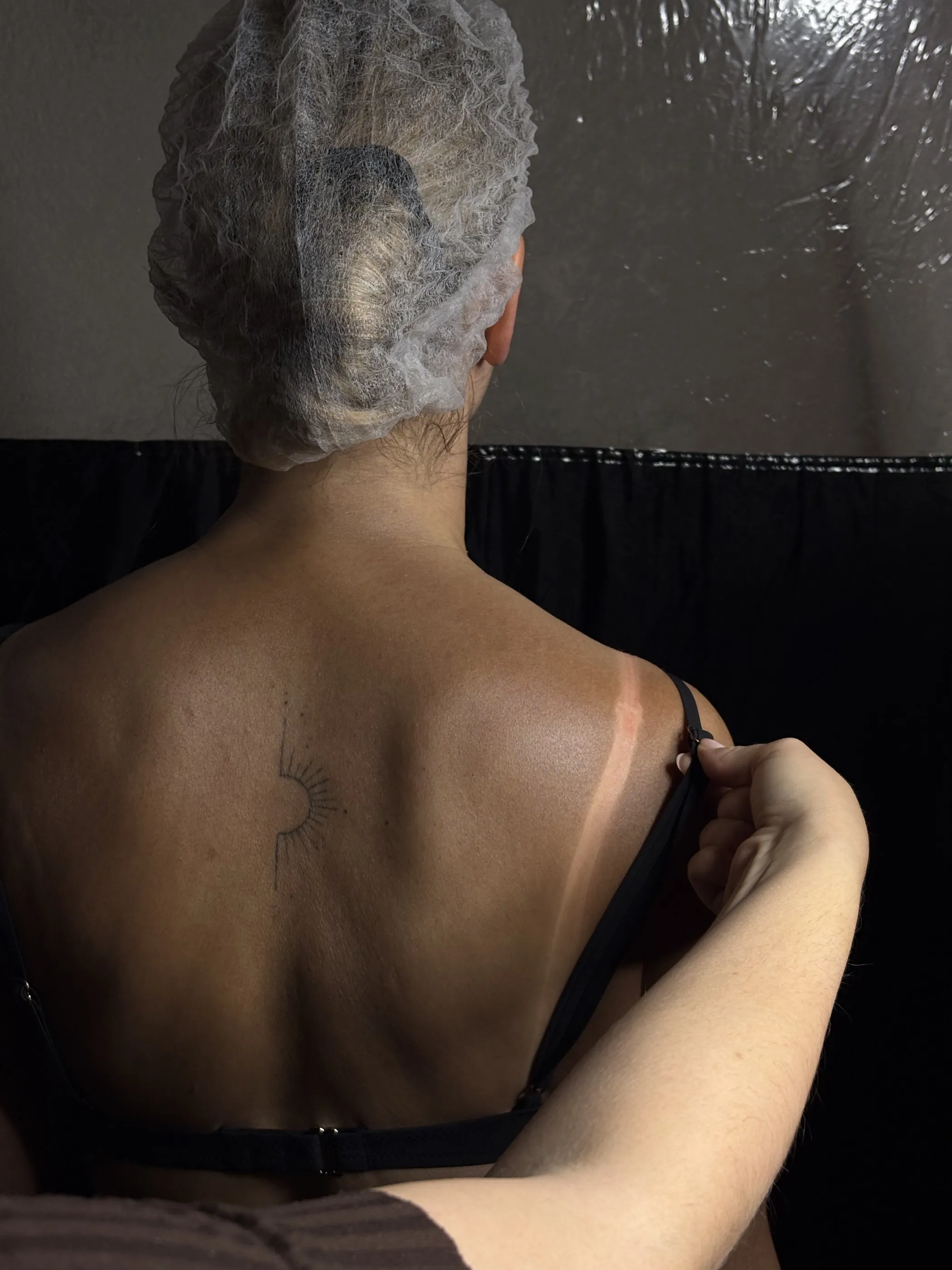 Chloé soulève la bretelle : la trace est nette sur le dos hâlé